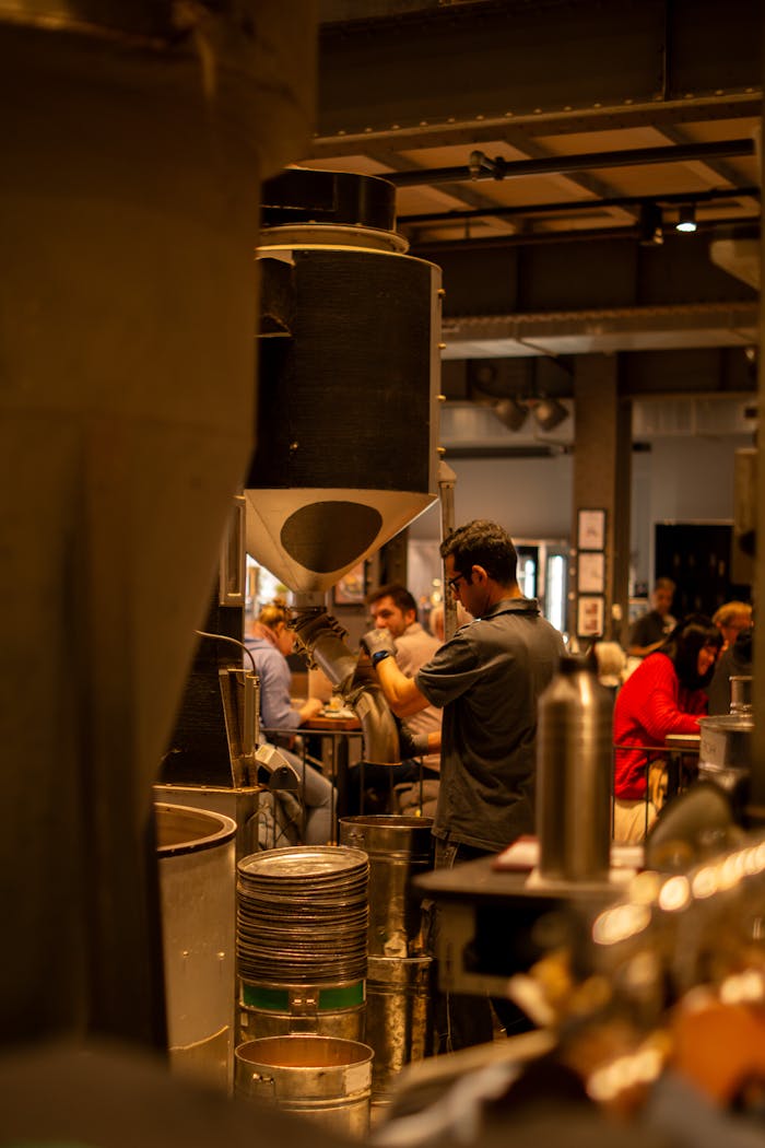 Home Cozy industrial coffee shop in Hamburg, Germany, with a warm atmosphere and barista at work.